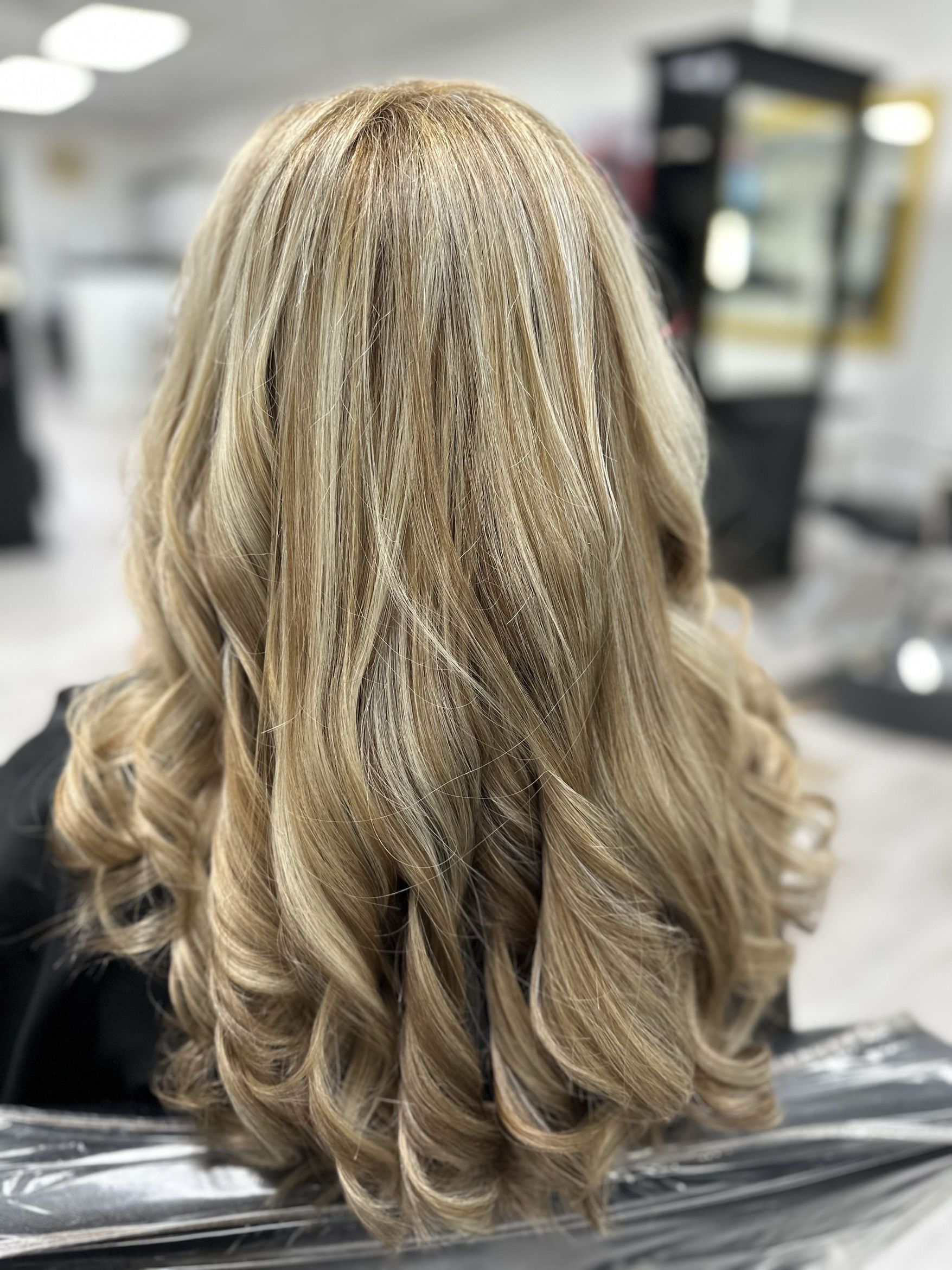 Long curled blonde hair styled at Blondie Hair Salon FL