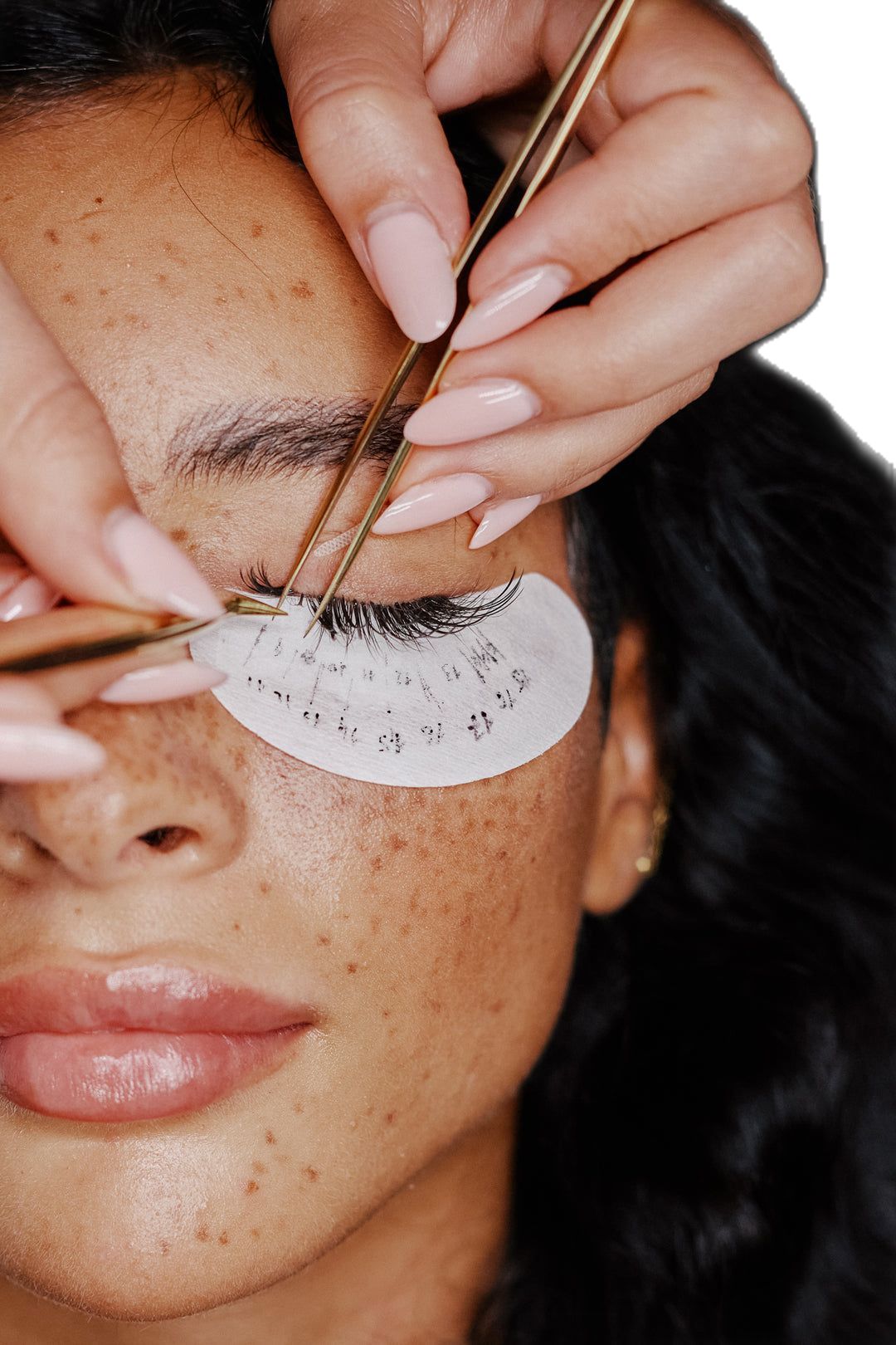 Lash extension application close-up with tweezers